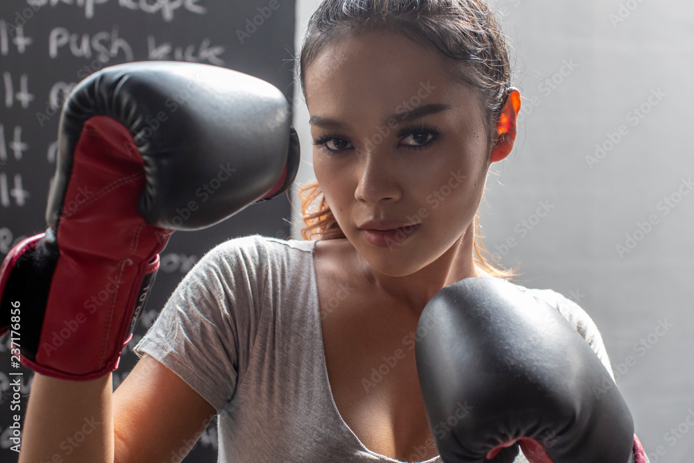 Thai transgender model in a Thai Box (Muay Thai) gym wearing boxing gloves