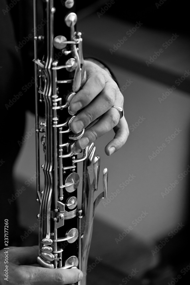 Fototapeta premium The hand of a musician playing the bass clarinet closeup in black and white