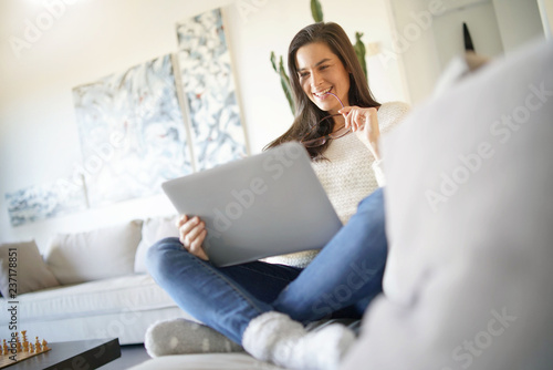  Beautiful woman relaxing at home with laptop