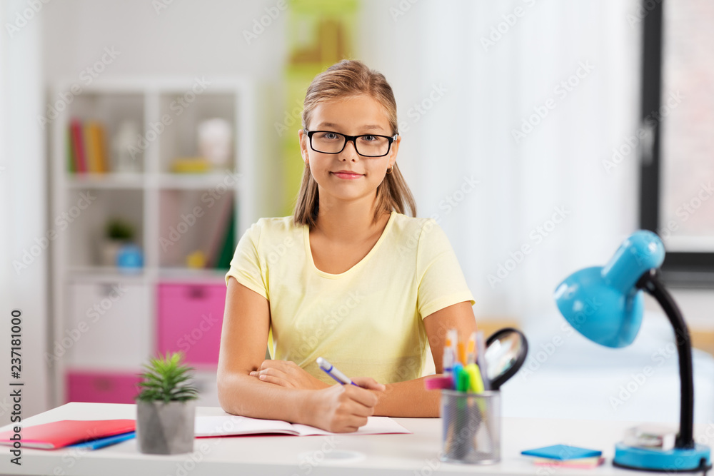 education and learning concept - happy student girl doing homework at home education and learning concept - happy student girl doing homework at home