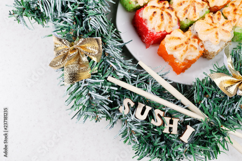 Christmas sushi. New Year sushi. Sushi and Christmas wreath and the Word SUSHI. View from above.