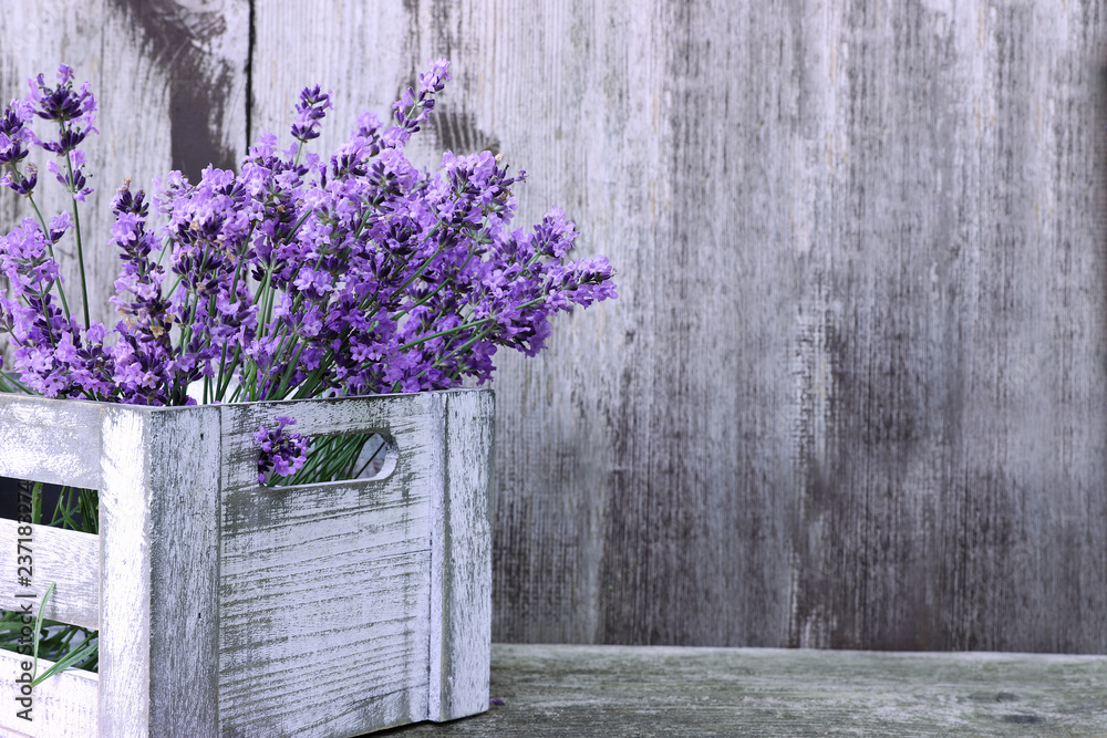 Obraz premium Lawenda kwitnie w pudełku na drewnianym tle