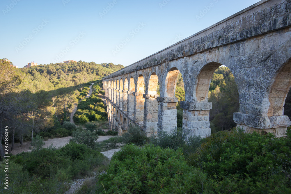 Ancient viaduct bridge from the bottom view in the setting sun