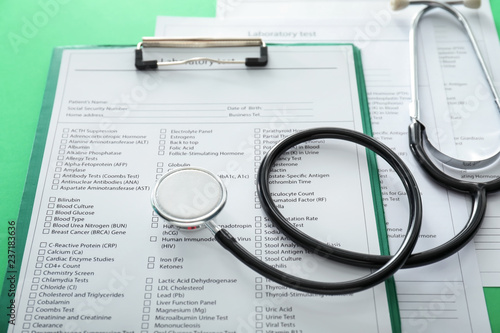 Stethoscope with lists of laboratory tests on color background. Health concept
