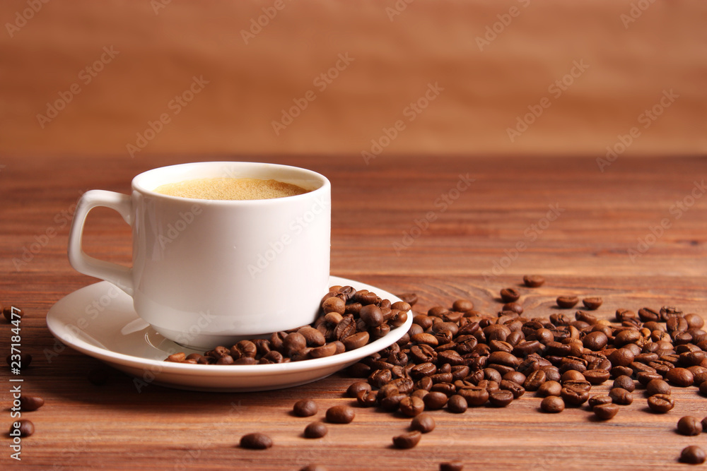 Cup of aromatic coffee and coffee beans on a wooden background. Cup of aromatic coffee and coffee beans on a wooden background.