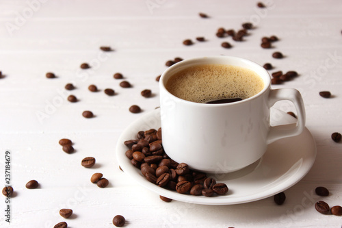 Cup of aromatic coffee and coffee beans on wooden background. Top view. Coffee drink