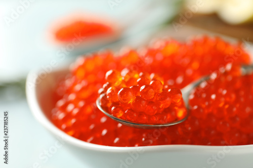Bowl and spoon with delicious red caviar, closeup
