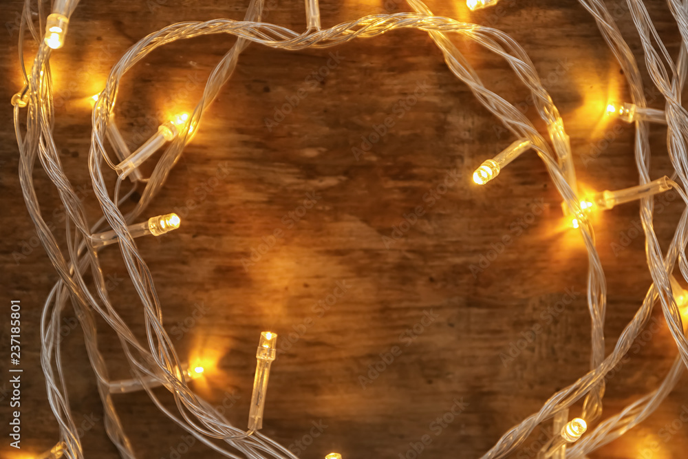 Glowing Christmas lights on wooden table