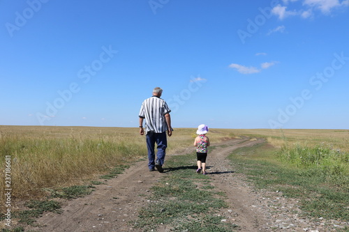 Man and child walking along the road