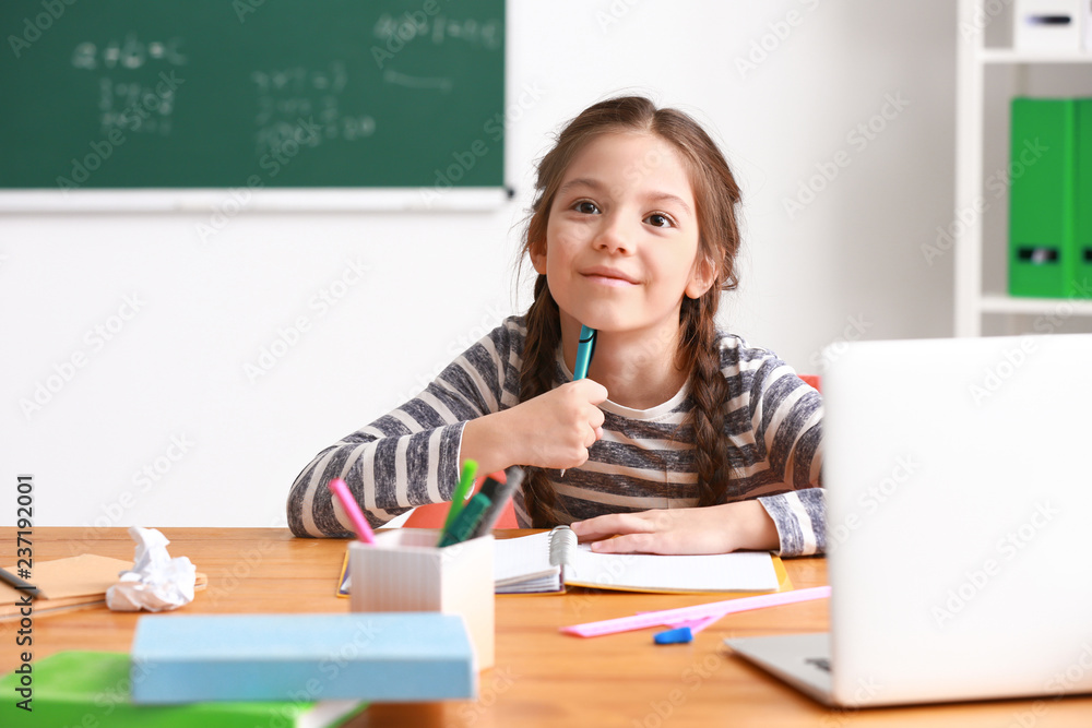 Cute girl doing homework in classroom Cute girl doing homework in classroom