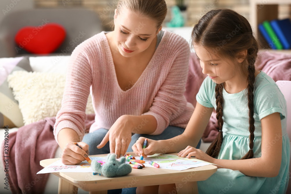 Cute girl with mother doing homework at home Cute girl with mother doing homework at home