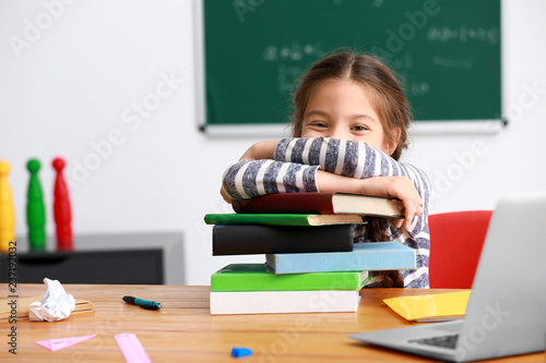 Cute girl with stack of boo...