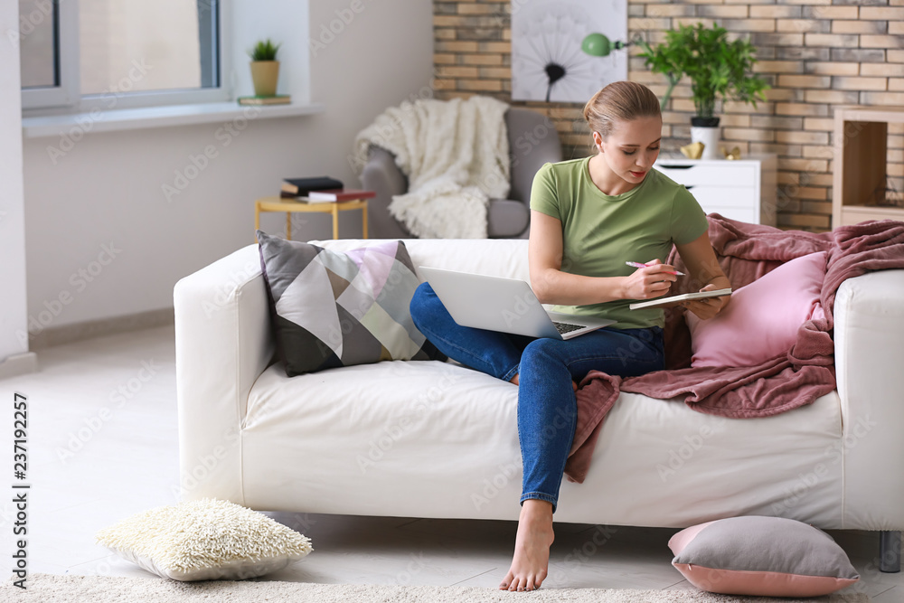 Obraz premium Female student with laptop studying at home