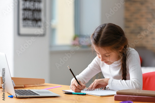 Cute girl doing homework at home photo