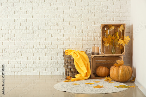 Beautiful autumn composition with pumpkins and leaves near white brick wall photo