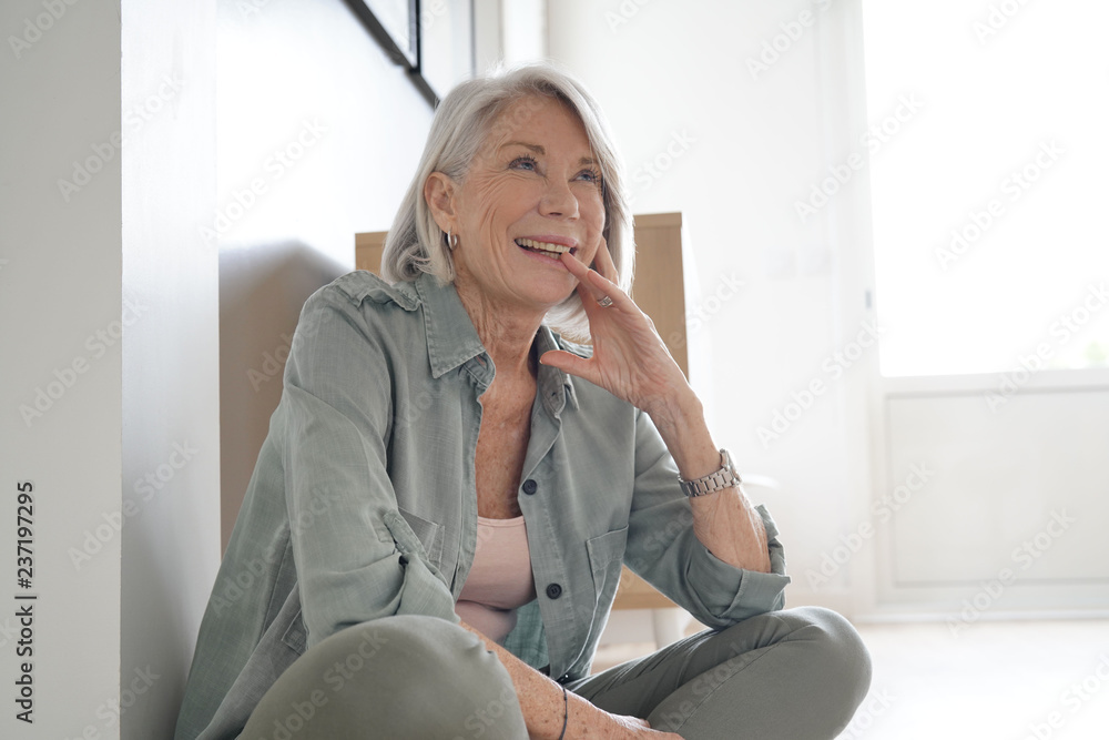 Attractive senior woman sitting on the floor at home Attractive senior woman sitting on the floor at home