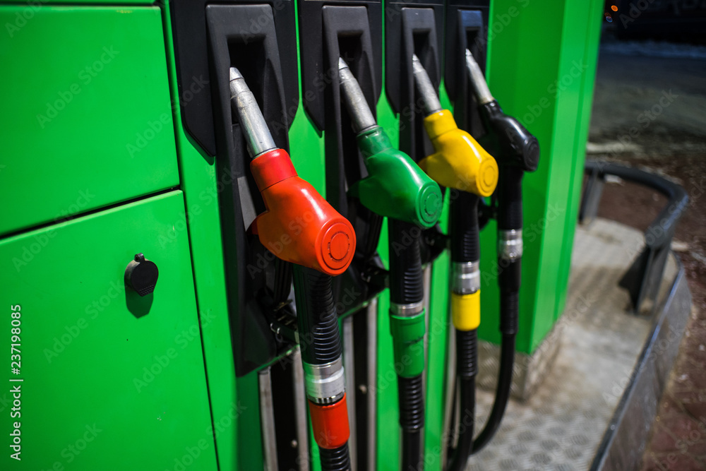 Fueling nozzles in different colors on green bright station Fueling nozzles in different colors on green bright station