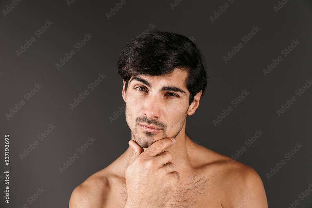 Handsome thoughtful serious young smiling man posing isolated over dark wall background. Handsome thoughtful serious young smiling man posing isolated over dark wall background.