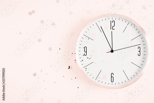 Winter composition. New year clock and decorationson pastel pink background. Christmas, New Year, winter concept. Flat lay, top view, copy space