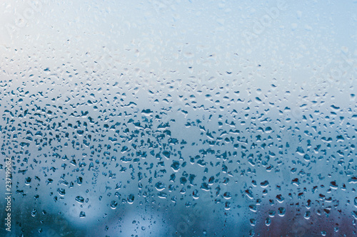 Strong humidity in wintertime. Water drops from home condensation on a window. Misted glass background