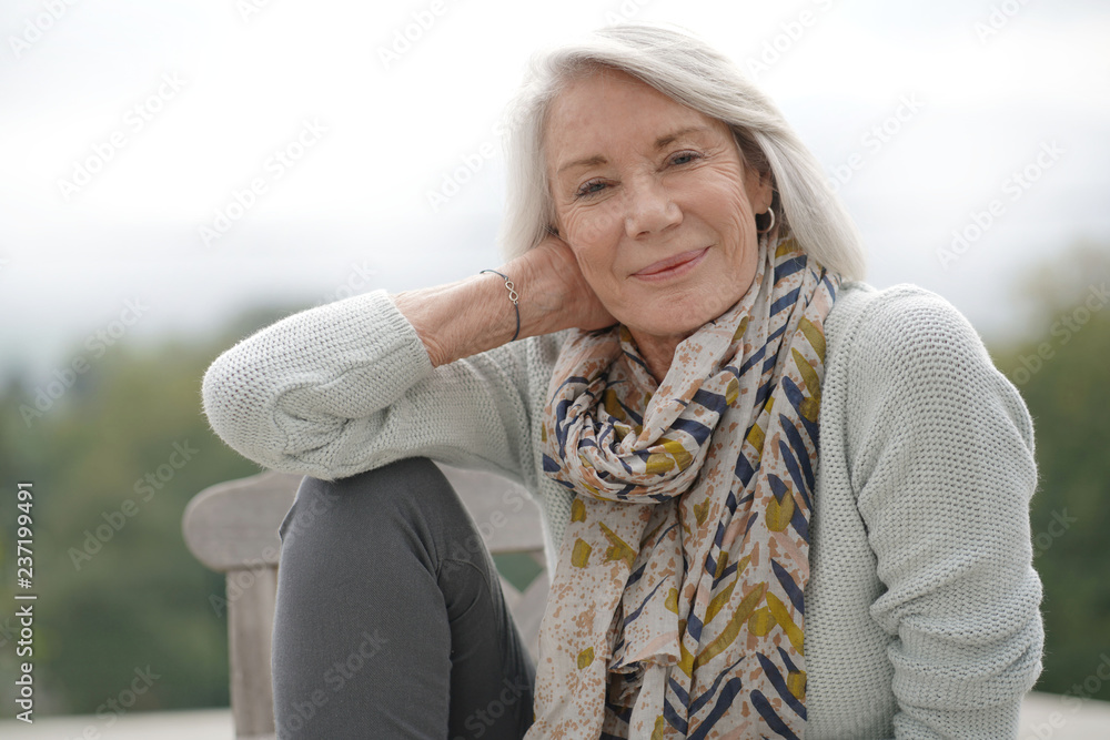 Beautiful senior womam sitting outdoors looking peaceful Beautiful senior womam sitting outdoors looking peaceful