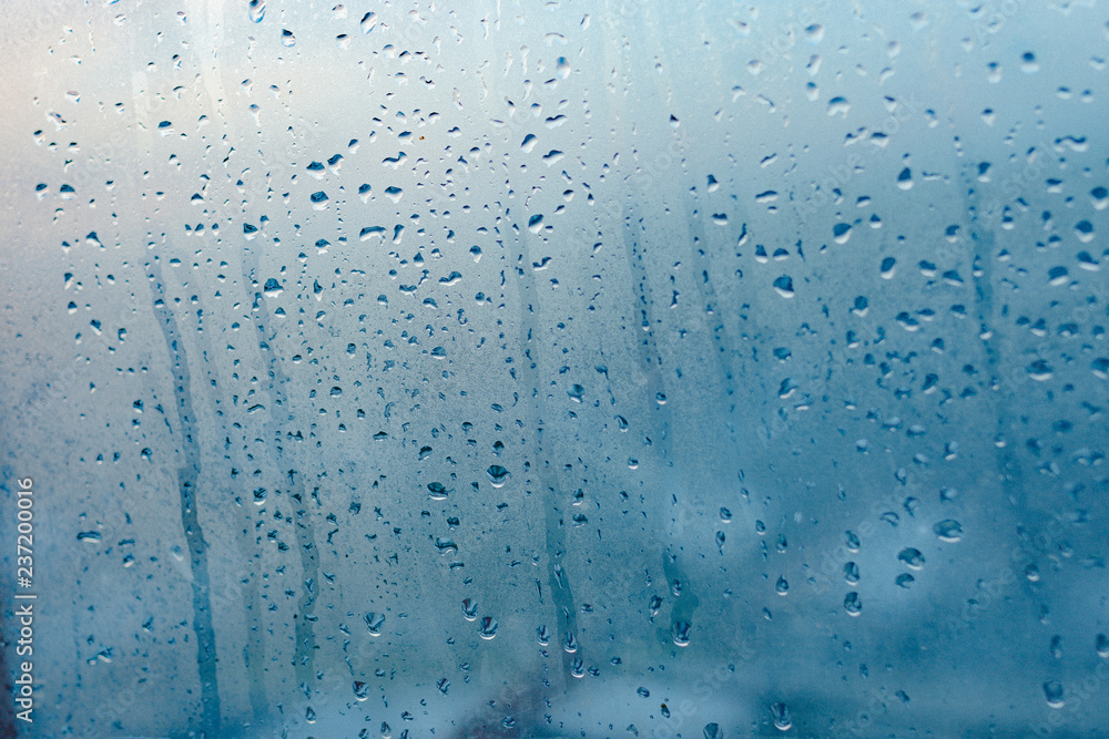 Strong humidity in wintertime. Water drops from home condensation on a window. Misted glass background Strong humidity in wintertime. Water drops from home condensation on a window. Misted glass background