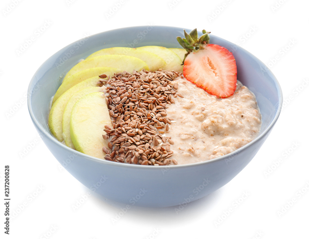 Bowl with tasty oatmeal, sliced pear and strawberry on white background