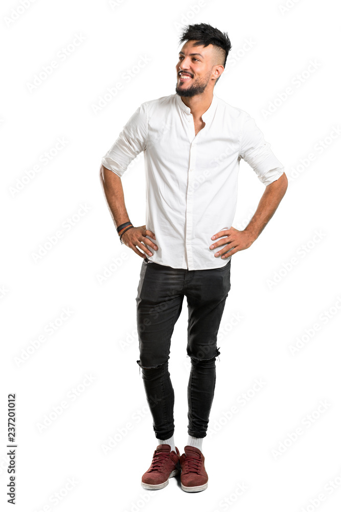 A full-length shot of a Arabic young man with white shirt posing with arms at hip on isolated white background A full-length shot of a Arabic young man with white shirt posing with arms at hip on isolated white background