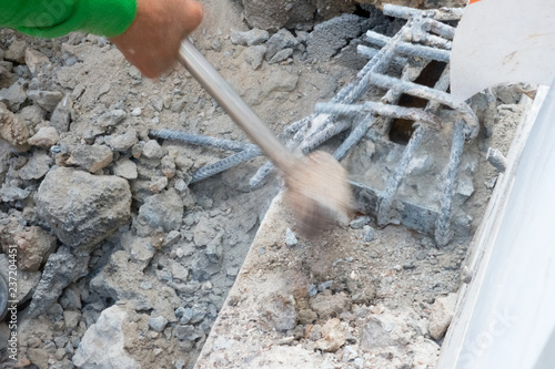 Building worker hitting with sledge hammer