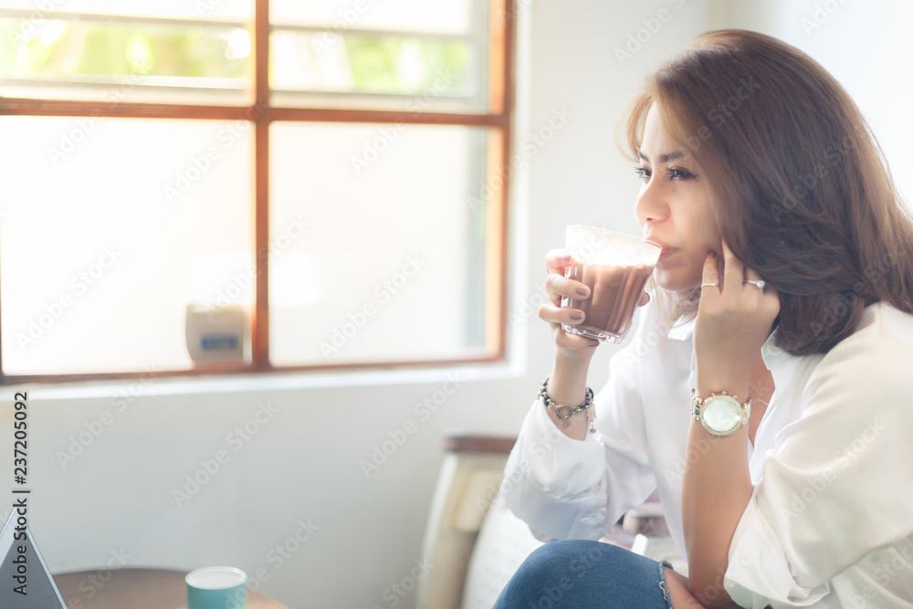 Woman in white shirt with drinking hot chocolate in the cafe, so relaxing. Woman in white shirt with drinking hot chocolate in the cafe, so relaxing.