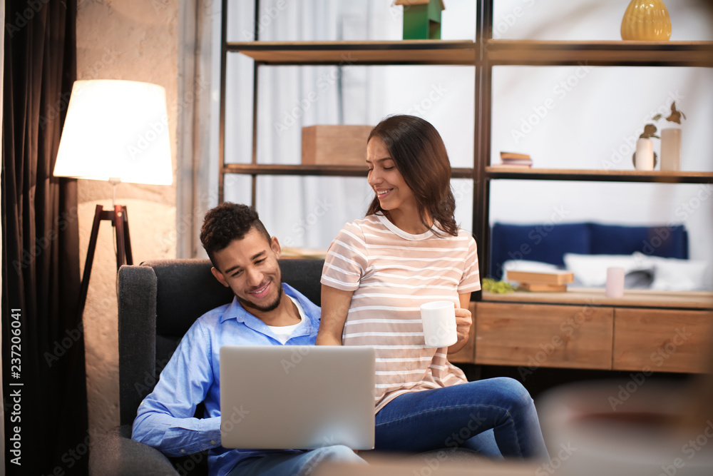 © Pixel-Shot - Young couple with laptop resting at home
