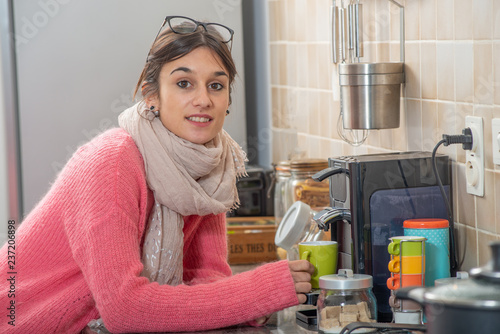 young brunette woman drinking coffee in the kitchen