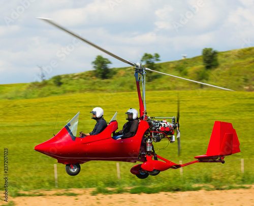 Gyroplane landing over green field