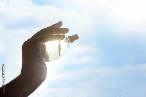 Woman holding bottle of perfume outdoors