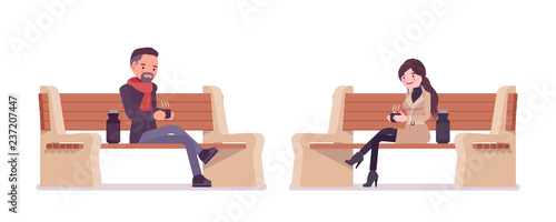 Stylish man and woman in autumn clothes sitting on bench