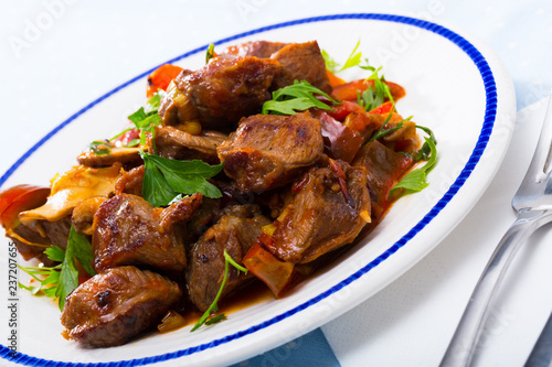 Delicious fried pork with button mushroom, peppers and greens