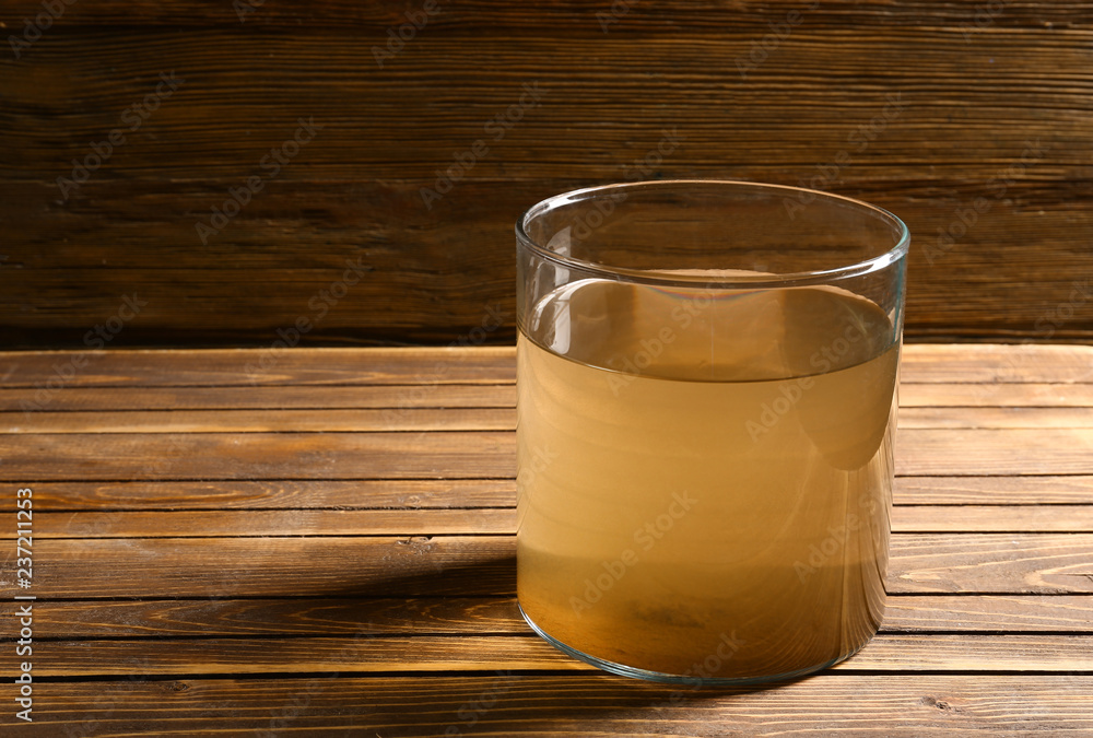 Glass of dirty water on wooden table Glass of dirty water on wooden table