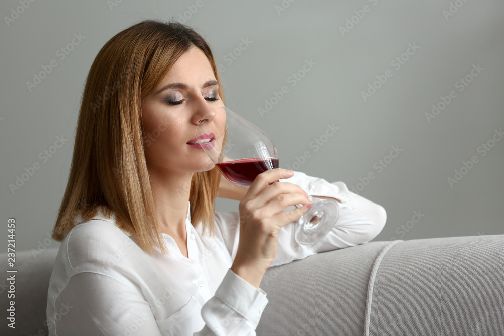 Beautiful woman smelling aroma of red wine at home Beautiful woman smelling aroma of red wine at home