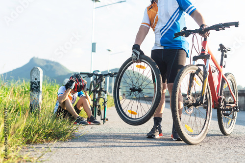 Принти на полотні woman cycling has a problem during the way needs flat tire repairing,helping by