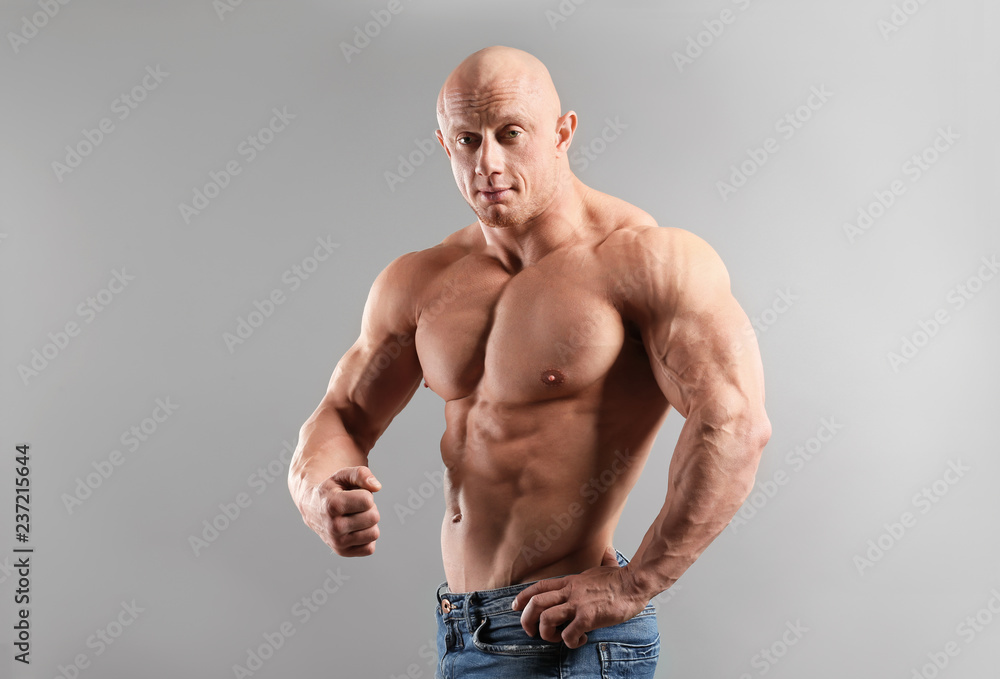 Fototapeta premium Muscular bodybuilder on grey background
