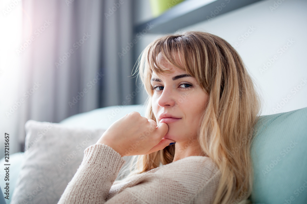 Woman at home deep in thoughts thinking and planning, looking at camera Woman at home deep in thoughts thinking and planning, looking at camera