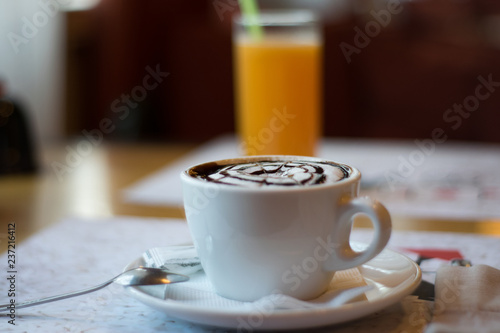 still life with a cup of flavored cappuccino  a phone on the background of a glass of orange juice. wallpaper