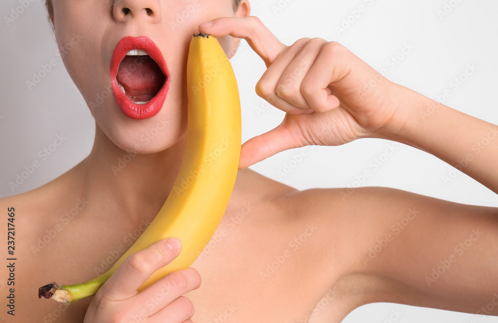 Sexy young woman with banana on light background. Erotic concept Stock  Photo | Adobe Stock