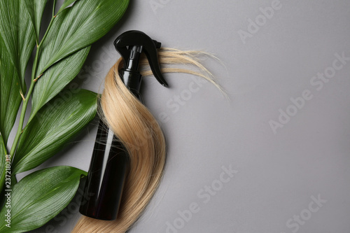Valokuvatapetti Spray bottle with cosmetic for hair on grey background, top view