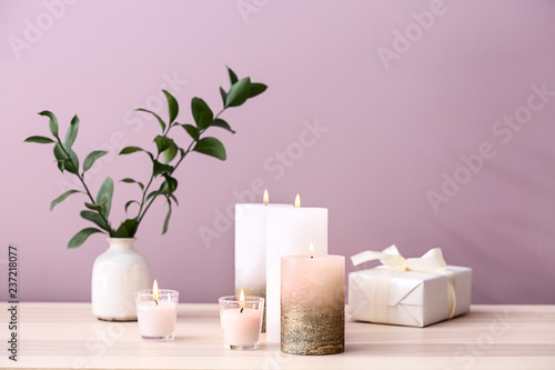 Composition with burning candles on wooden table