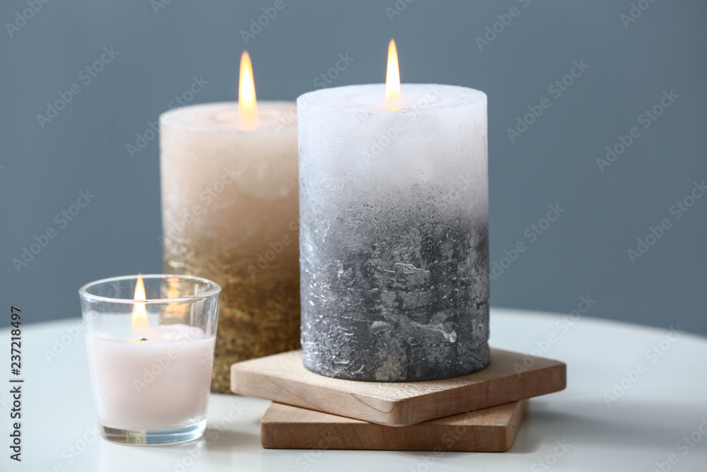 Beautiful composition with burning candles on table near color wall Beautiful composition with burning candles on table near color wall