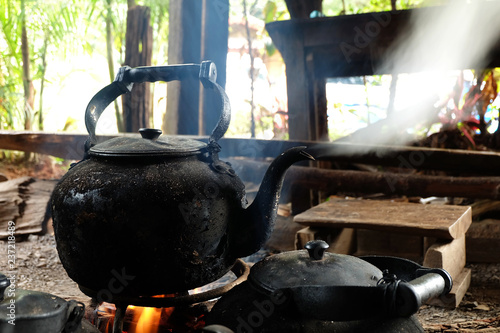 Old black kettle boiling is on charcoal stove