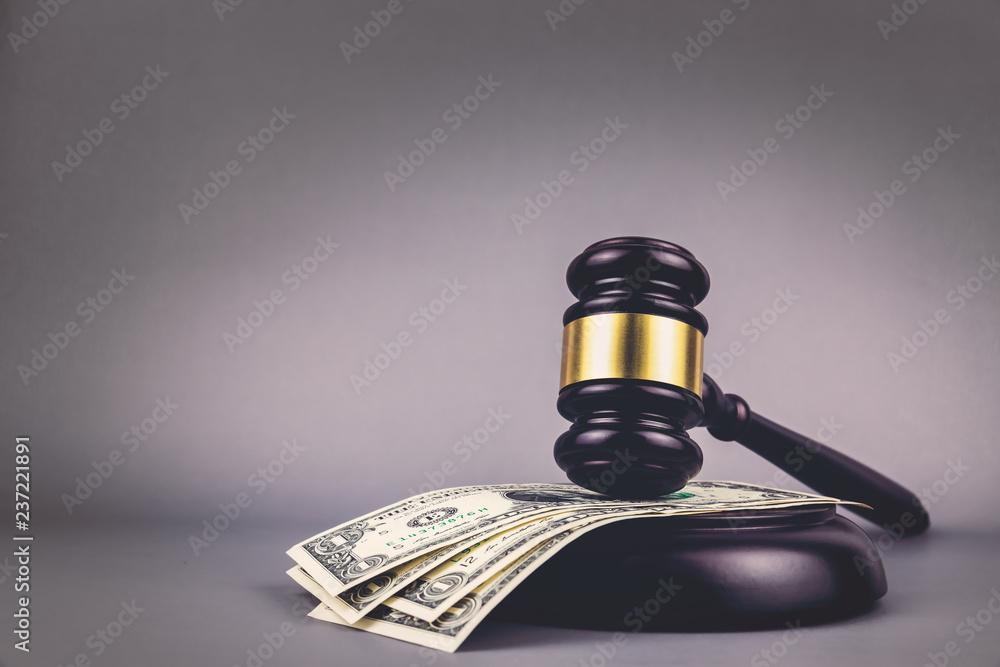 Judges gavel on dollar with gray background