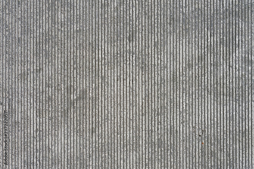 Texture of gray concrete wall with vertical cutouts. Texture of old gray concrete wall for background. Empty urban interior.