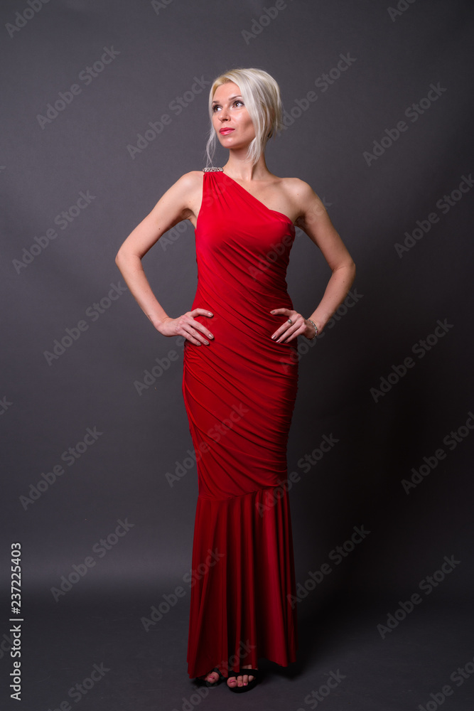 Full length portrait of beautiful woman with blond hair wearing red dress Full length portrait of beautiful woman with blond hair wearing red dress